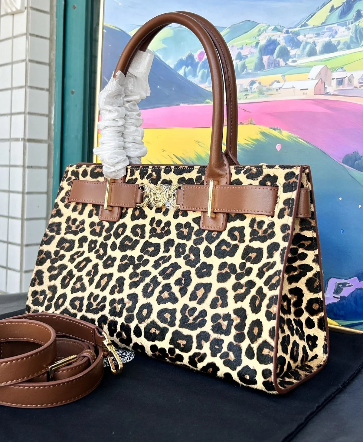 Versace Leopard Tote Bag with brown leather handle and gold Medusa hardware on a dust bag. - Hình 4