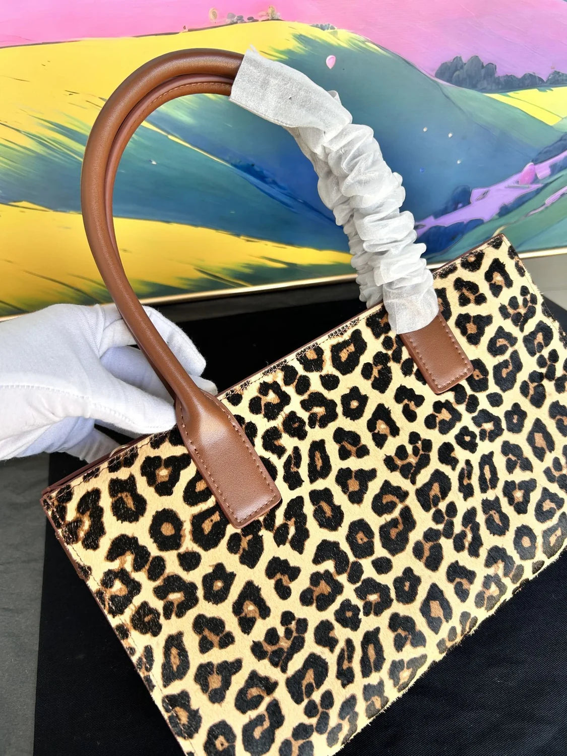 Versace Leopard Tote Bag with brown leather handle and gold Medusa hardware on a dust bag. - Hình 5
