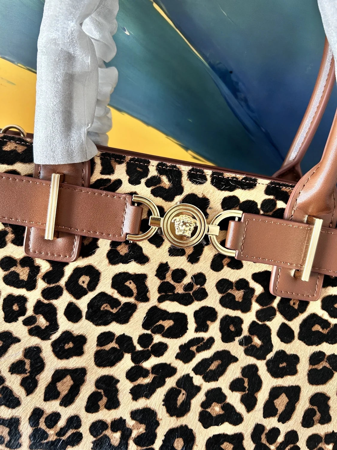 Versace Leopard Tote Bag with brown leather handle and gold Medusa hardware on a dust bag. - Hình 7